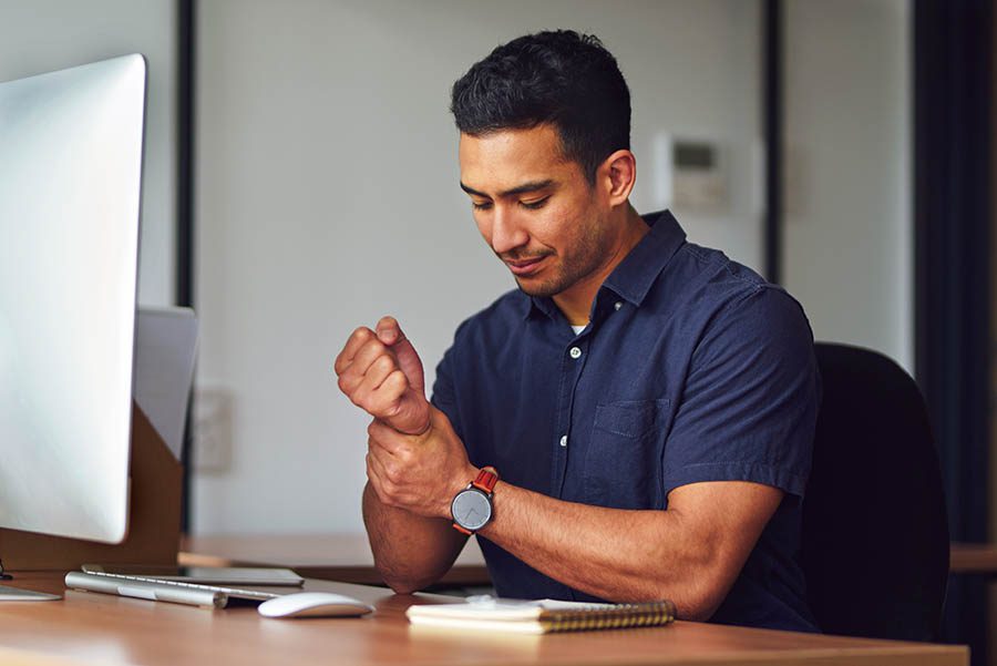Shot of a young man clutching his wrist in pain